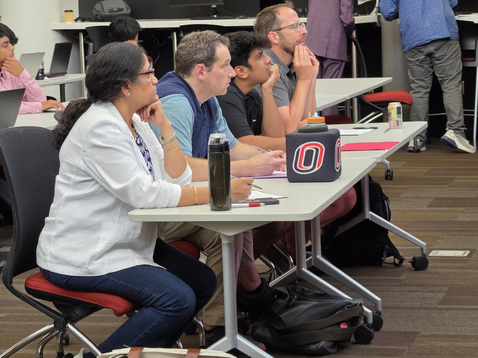 Judges listen to high school student presentations.