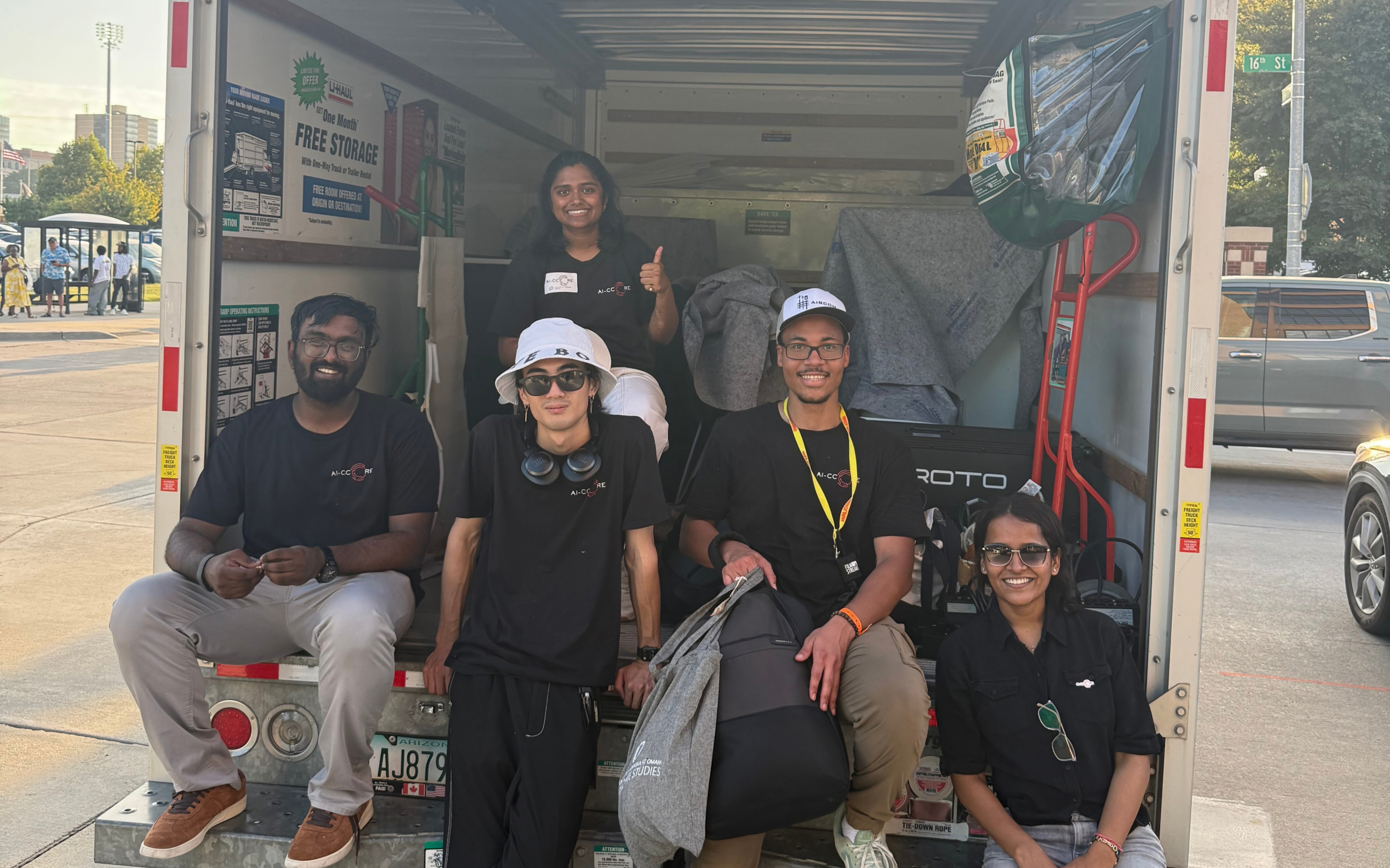AI-CCORE graduate assistants, student workers, and staff gathered at the open back of the exhibit truck in downtown Omaha after Afro Fest Omaha.